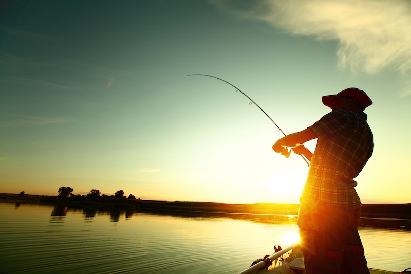 Man fishing at sunset on the edge of a lake in Summerton NC