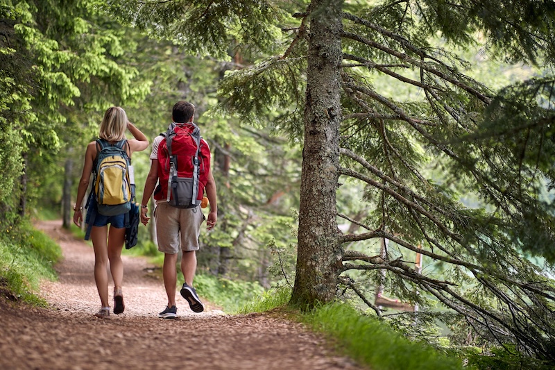Young couple walking down a hiking trail out in the wilderness